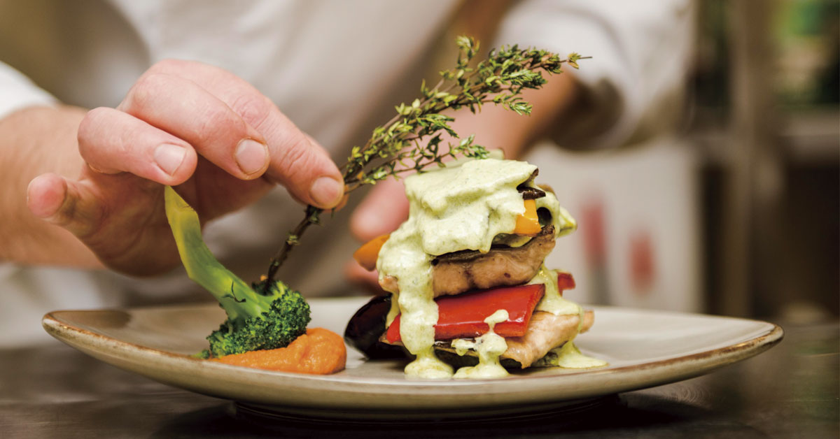 chef poniendo hierba aromatica en plato