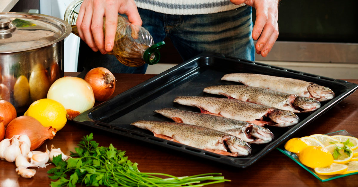 hombre cocinando pescado al horno