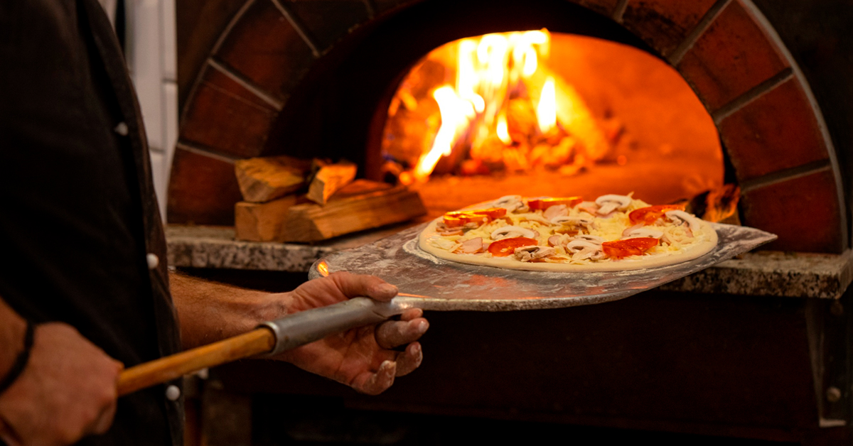 pizzero metiendo pizza en el horno